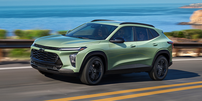 A green 2025 Chevy Trax parked in a scenic park near Seminole, OK driving down the highway.