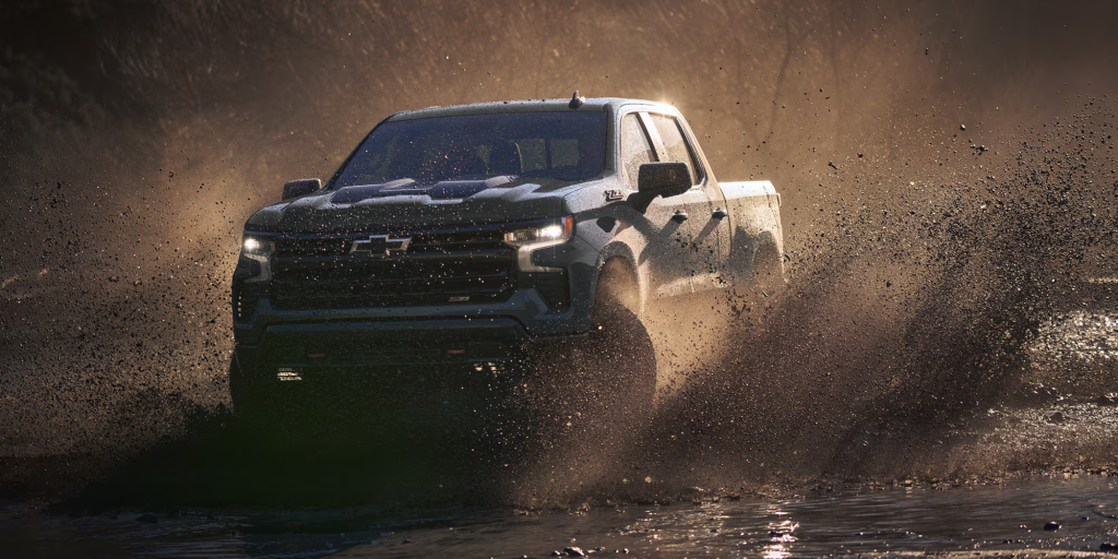 Chevrolet Silverado 1500 driving through muddy water with powerful off-road performance.