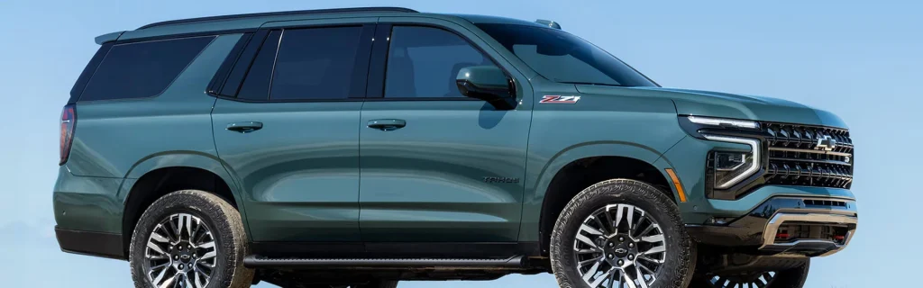 Green Chevrolet Tahoe Z71 SUV shown in a side profile against a clear sky.